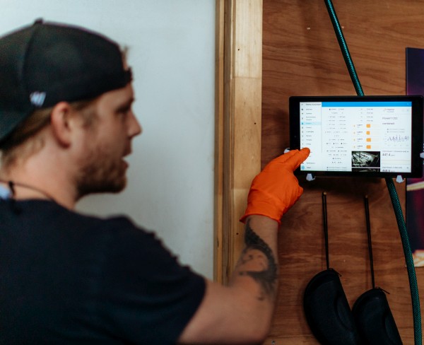 Josiah pointing to a tablet of grow room data