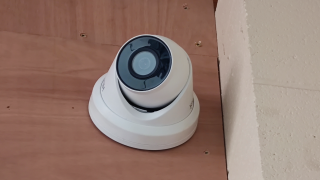 A dome-style security camera mounted to a wall